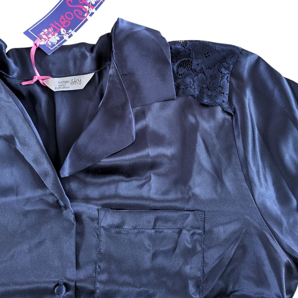 Navy satin jacket with a tag on a white background
