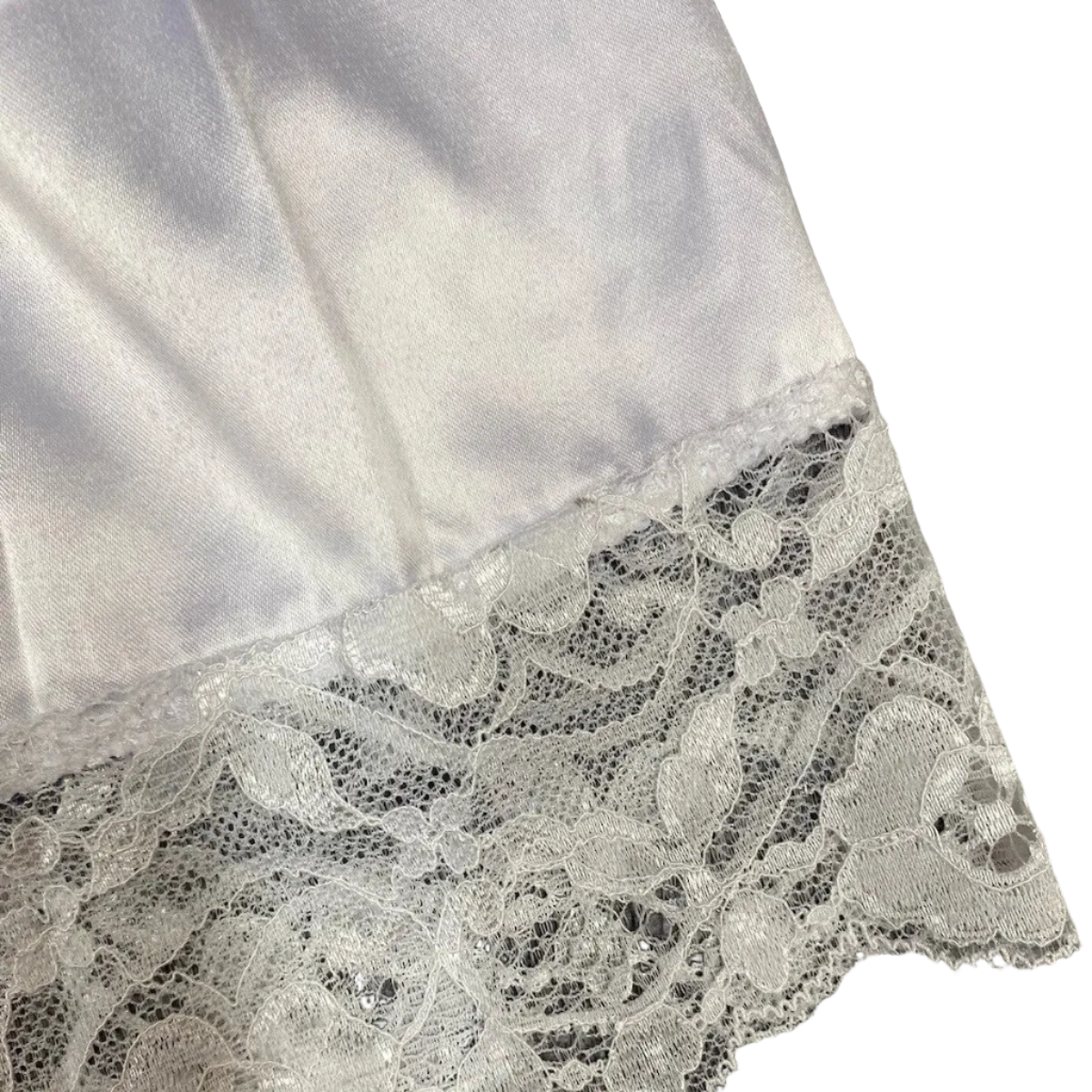 Close-up of lace trim on a white fabric against a dark background