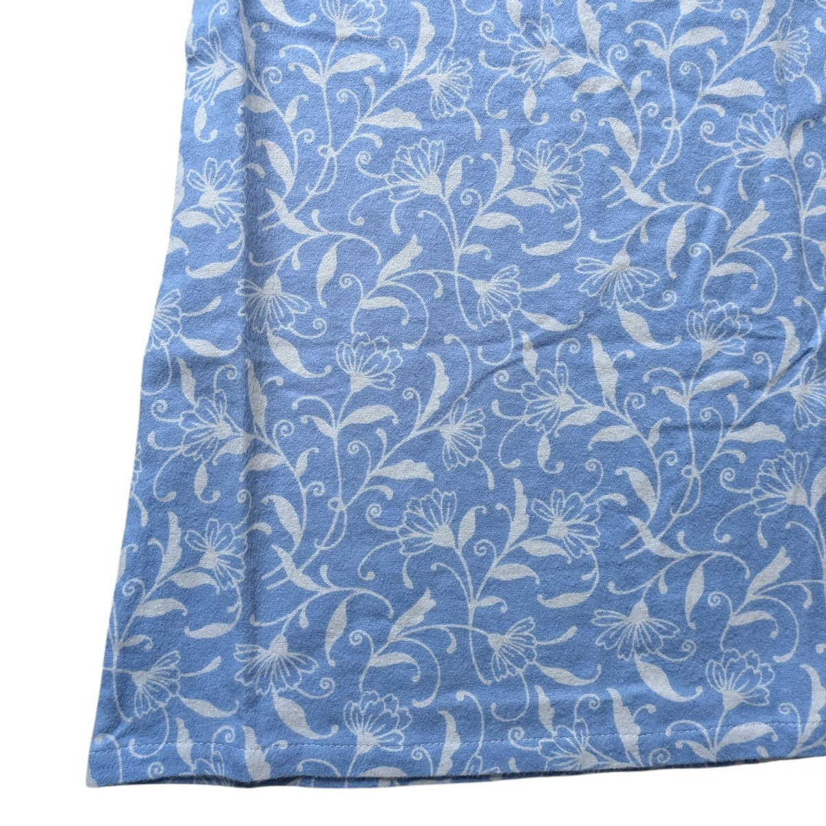 Blue fabric with white floral pattern on a white background