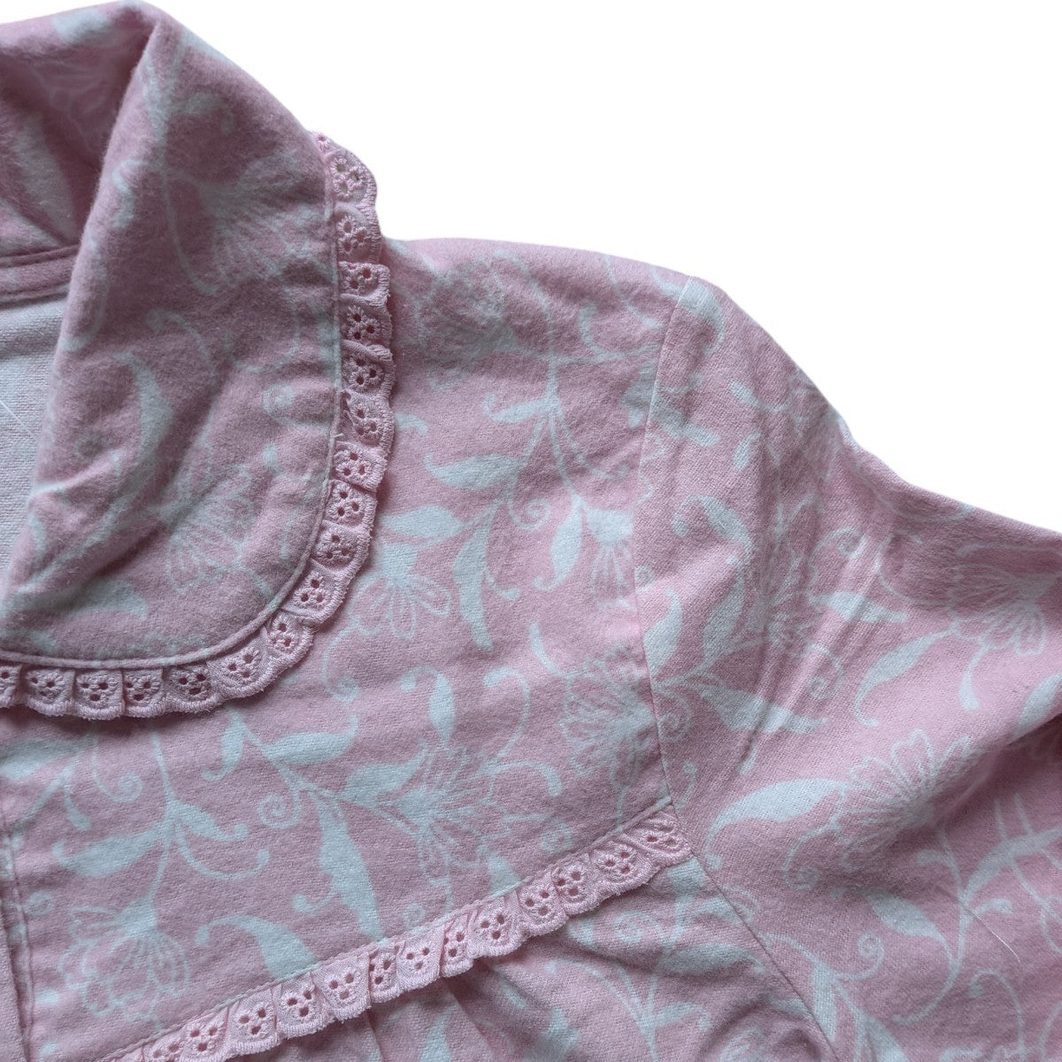 Pink floral patterned fabric with lace trim on a white background