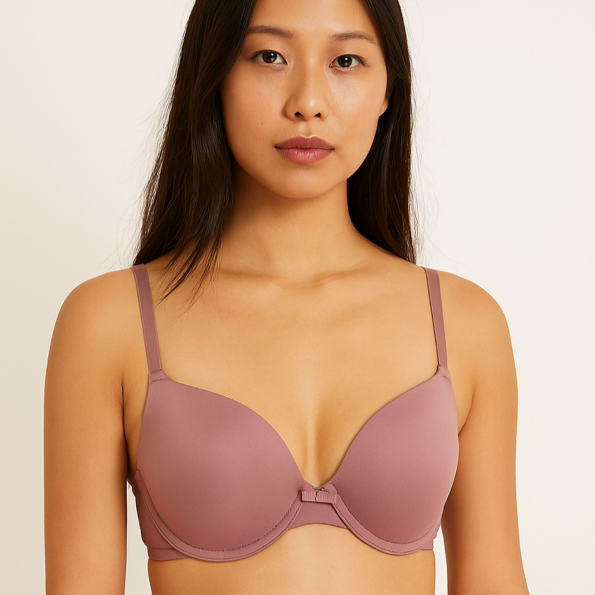 Woman wearing a mauve bra against a plain background